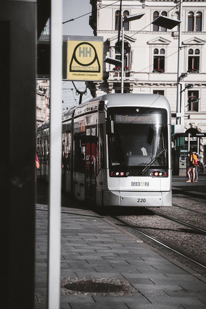A modern tram navigates the urban streets of Graz, Austria, passing historic architecture.